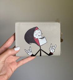 a hand holding a wallet with a cartoon character on it