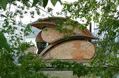 a building made out of wood sitting on top of a lush green forest