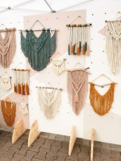 there are many different types of macrame hanging on the wall with wooden pegs