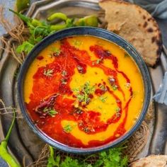 a bowl of soup with bread on the side