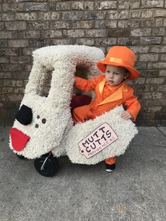 a little boy dressed in an orange and white car costume