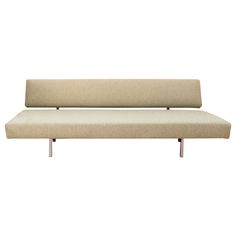 a beige couch sitting on top of a white floor