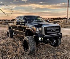 a black truck parked on top of a dry grass field