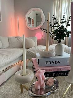 a living room filled with lots of white furniture and candles on top of each other