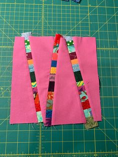 two pieces of pink fabric on a cutting board