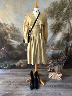 Super cute vintage 80s Pierre Cardin midi dress! It is a beige tan color with a large sailor collar in the front and back that makes it so unique. The dress wraps and ties at the side. The long sleeves are secured with a buttons at the cuffs. Has pockets and shoulder pads. The dress can be worn with lace up boots, crossbody bag, and accessories. Or style it with sandals and a straw hat! Perfect summer dress!  Brand: Pierre Cardin Fabric- 100% cotton  Flaws: Stain at the waist (see photos) - some Beige Long Sleeve Vintage Dress In Cottagecore Style, Beige Long Sleeve Vintage Dress Cottagecore Style, Beige Long Sleeve Cottagecore Vintage Dress, Cottagecore Beige Long Sleeve Vintage Dress, Vintage Long Sleeve Beige Midi Dress, Vintage Beige Long Sleeve Midi Dress, Vintage Beige Midi Dress For Fall, Beige Long Sleeve Vintage Midi Dress, Vintage Cream Midi Dress With Long Sleeves