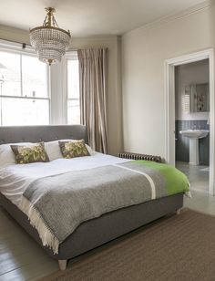 a bedroom with a large bed and a chandelier hanging from the ceiling