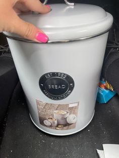 a woman's hand is on the lid of a white crock pot with buttons