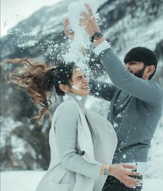 a man and woman playing in the snow