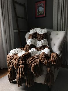 a white chair with a brown and white blanket on it