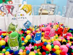 there are many different colored balls in the bowl and on the table, one is filled with plastic toys