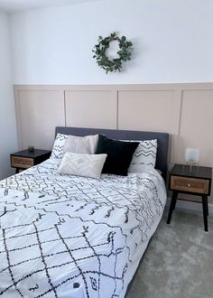 a bedroom with a bed, nightstands and a wreath on the wall