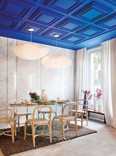 a dining room with blue painted ceilings and chairs