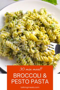 broccoli and pesto pasta on a white plate with a fork in it