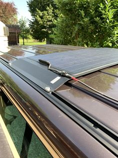 a solar panel on the roof of a car with trees in the backgroud