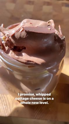 a jar filled with chocolate frosting on top of a wooden table