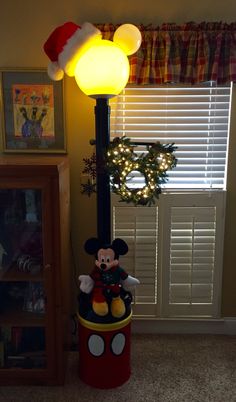 the mickey mouse lamp is lit up with christmas lights on it's head and ears