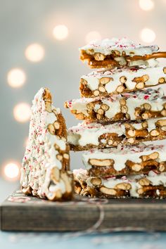 a stack of christmas cookies with white frosting and sprinkles on top