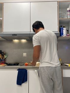 a man standing in front of a kitchen counter preparing food