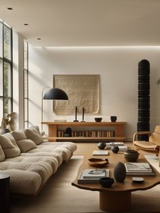 a living room filled with furniture and a tall lamp on top of a wooden table