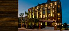 the hotel is lit up at night with palm trees