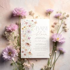 a baby shower with pink flowers and greenery