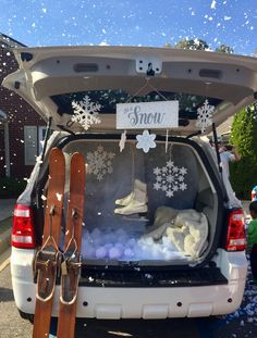 the back end of a car with skis and snowflakes in the trunk