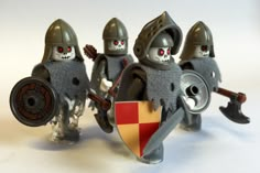 three lego knights with helmets and swords on white background, one is holding a shield while the other two are wearing red eyes