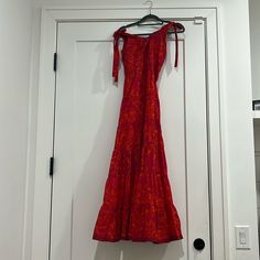 a red dress hanging on a white door