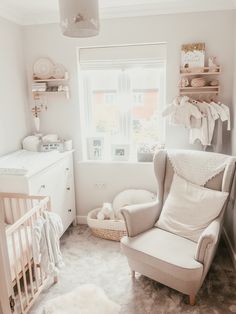 a baby's room with a chair, crib and window