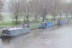 a small boat traveling down a river in the rain