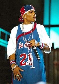 a man in a blue jersey holding a microphone and wearing a red, white and blue hat