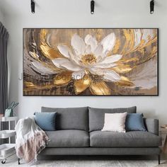 a living room with a gray couch and large painting on the wall above it's head