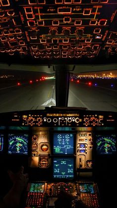 an airplane cockpit at night with the lights on