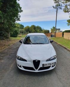 a white car is parked on the street