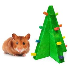 a hamster sitting next to a christmas tree made out of wooden pegs and colored magnets