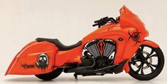 an orange motorcycle parked on top of a white floor