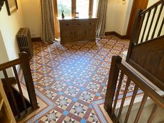 an entry way with tiled floors and wooden railings