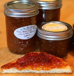 two jars of jam and a slice of bread on a table