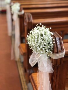 a bouquet of baby's breath sitting on the pews of a church