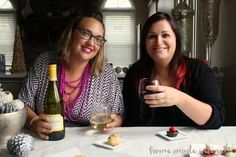 two women sitting at a table holding wine glasses