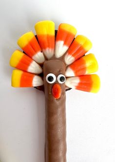 a chocolate stick with candy in the shape of a turkey on it's head