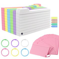 a set of colored sticky notes with ring binders and paper clips for notepads