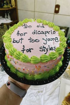 a person holding a cake with writing on it