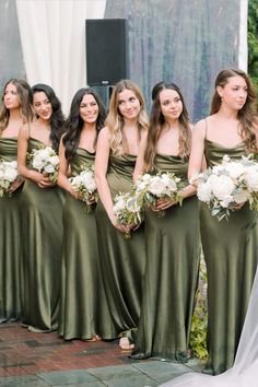 a group of women standing next to each other holding bouquets in front of them