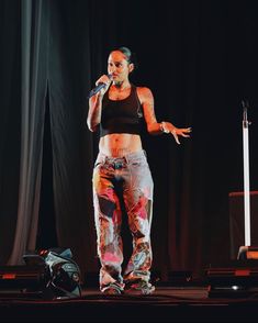 a woman standing on top of a stage holding a microphone