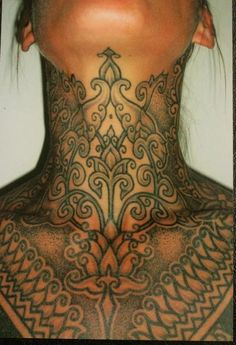 a woman with tattoos on her neck and chest