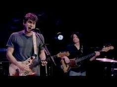 two young men are playing guitars on stage