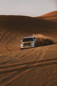 a white truck driving through the desert