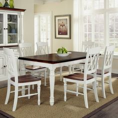 a dining room table with chairs and a bowl of fruit